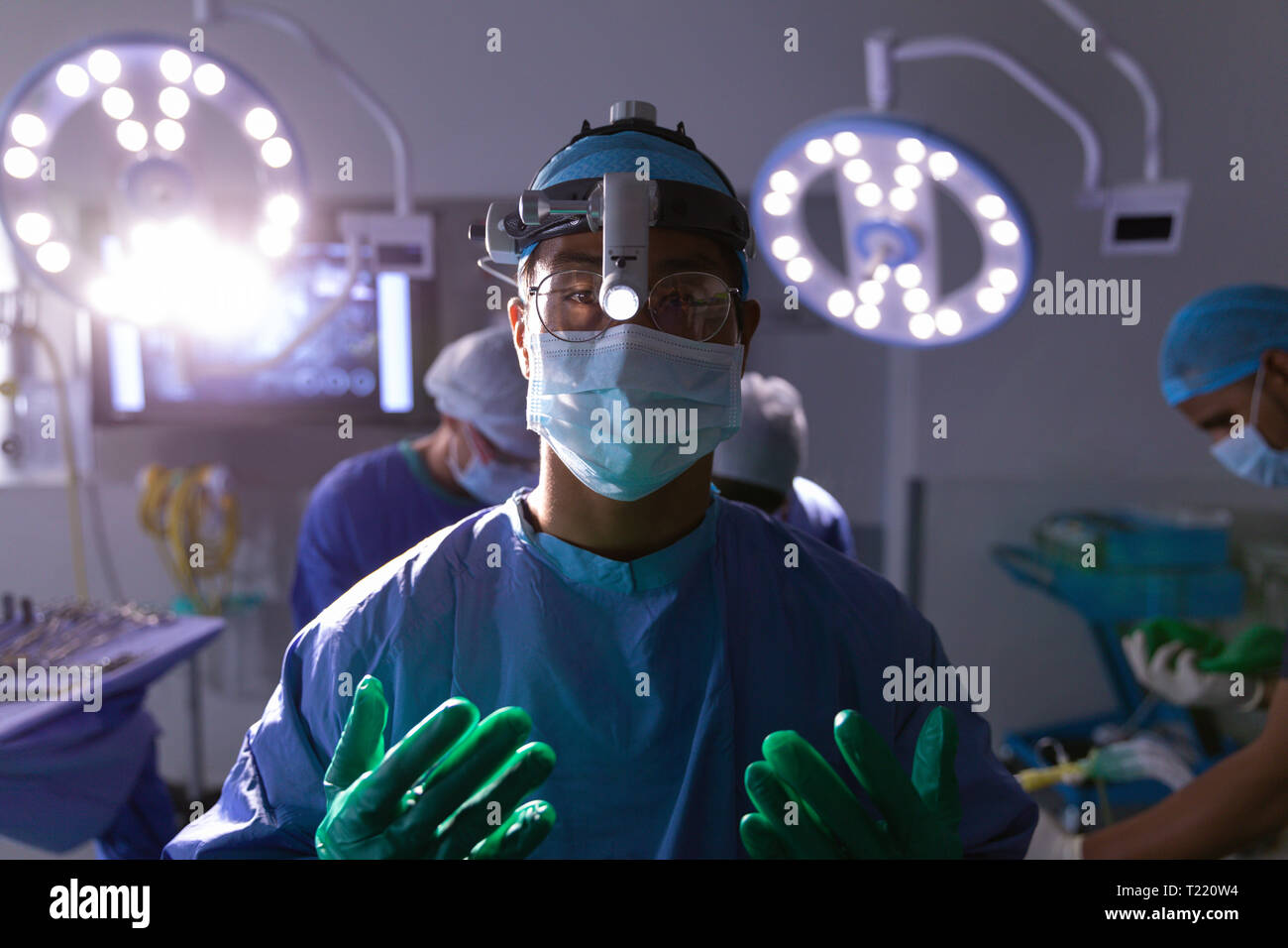 Chirurg stehen und an der Kamera im Operationssaal Stockfoto