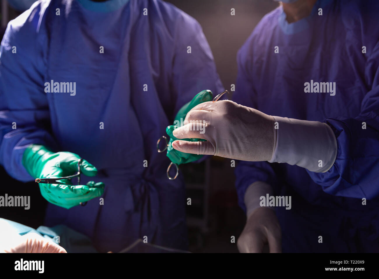 Chirurg, Pinzette, Schere, während Sie die andere gedrückt halten während der Operation Stockfoto