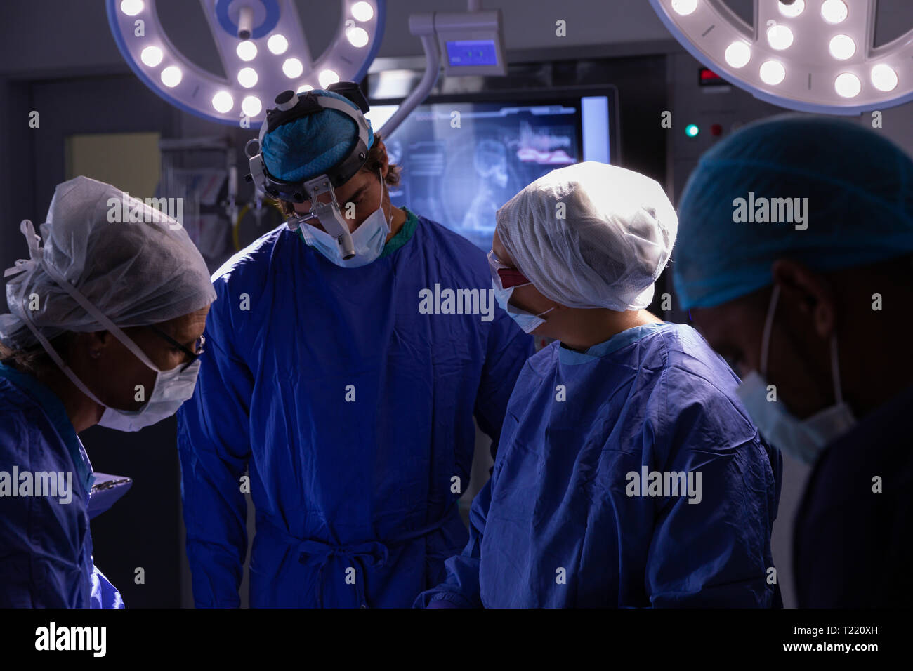 Chirurgen miteinander reden während der Operation im Operationssaal am Krankenhaus Stockfoto