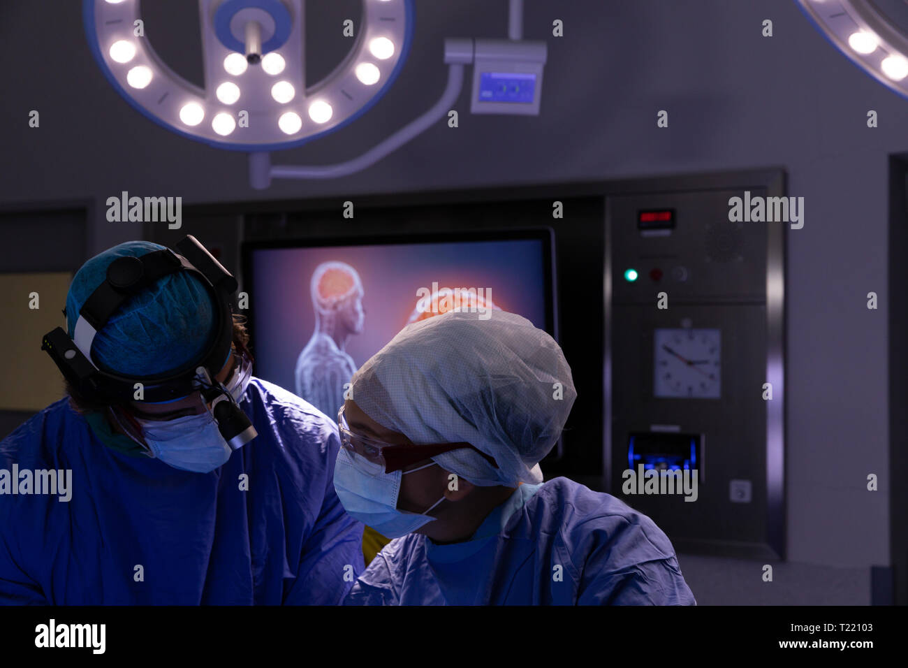 Chirurgen miteinander reden während der Operation im Operationssaal am Krankenhaus Stockfoto