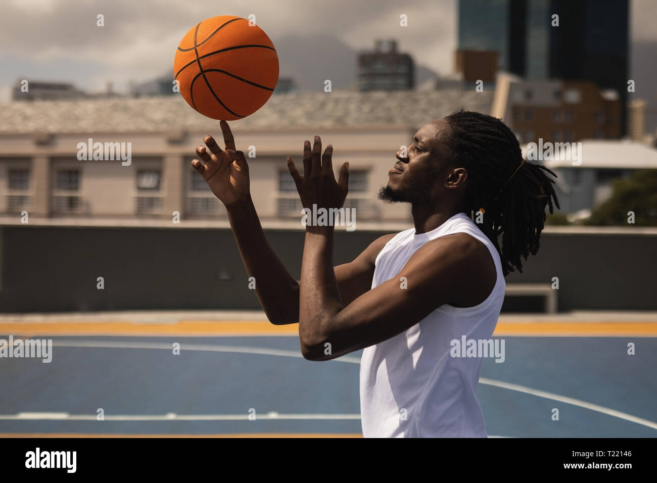 Basketball player balancing Ball auf dem Finger am Basketballplatz Stockfoto