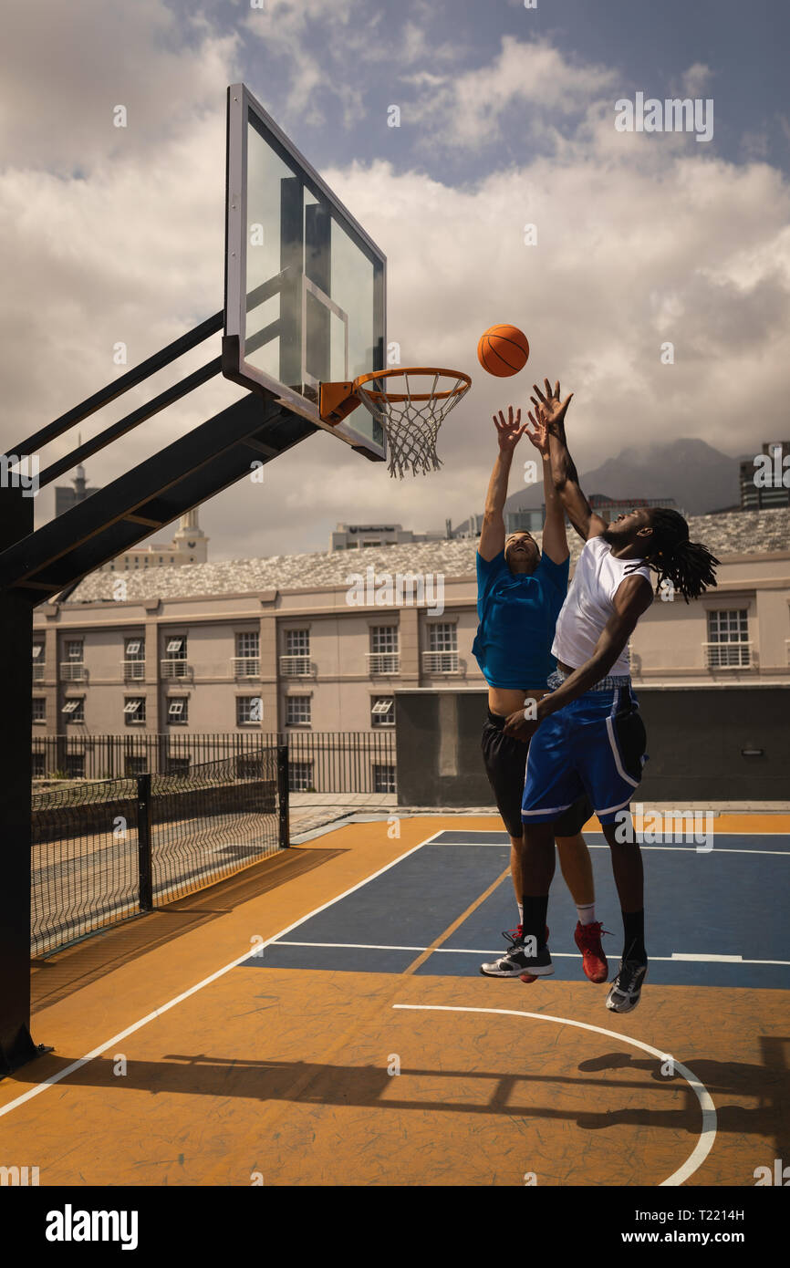 Basketballspieler Basketball spielen am Basketballplatz Stockfoto