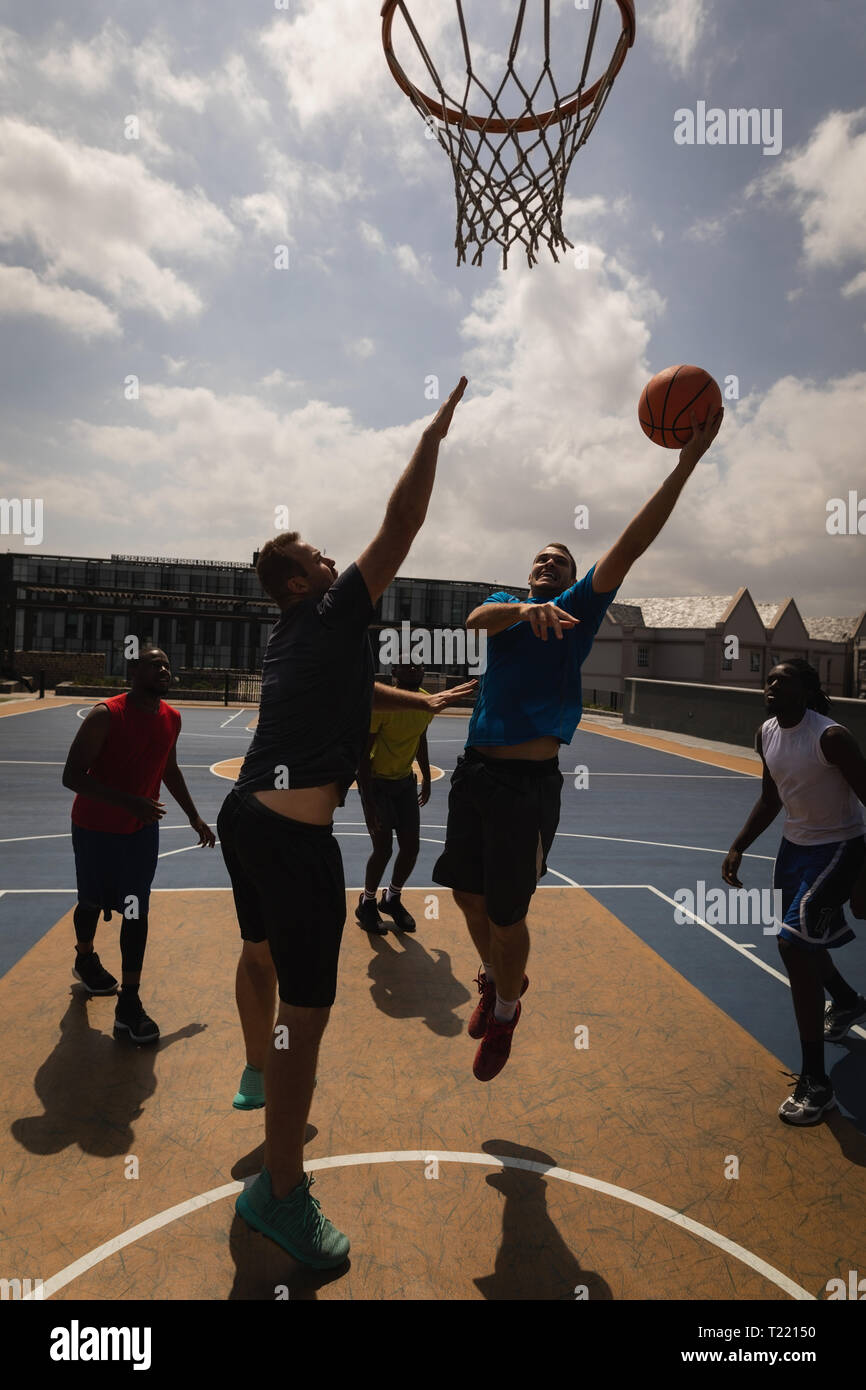 Basketballspieler Basketball spielen am Basketballplatz Stockfoto