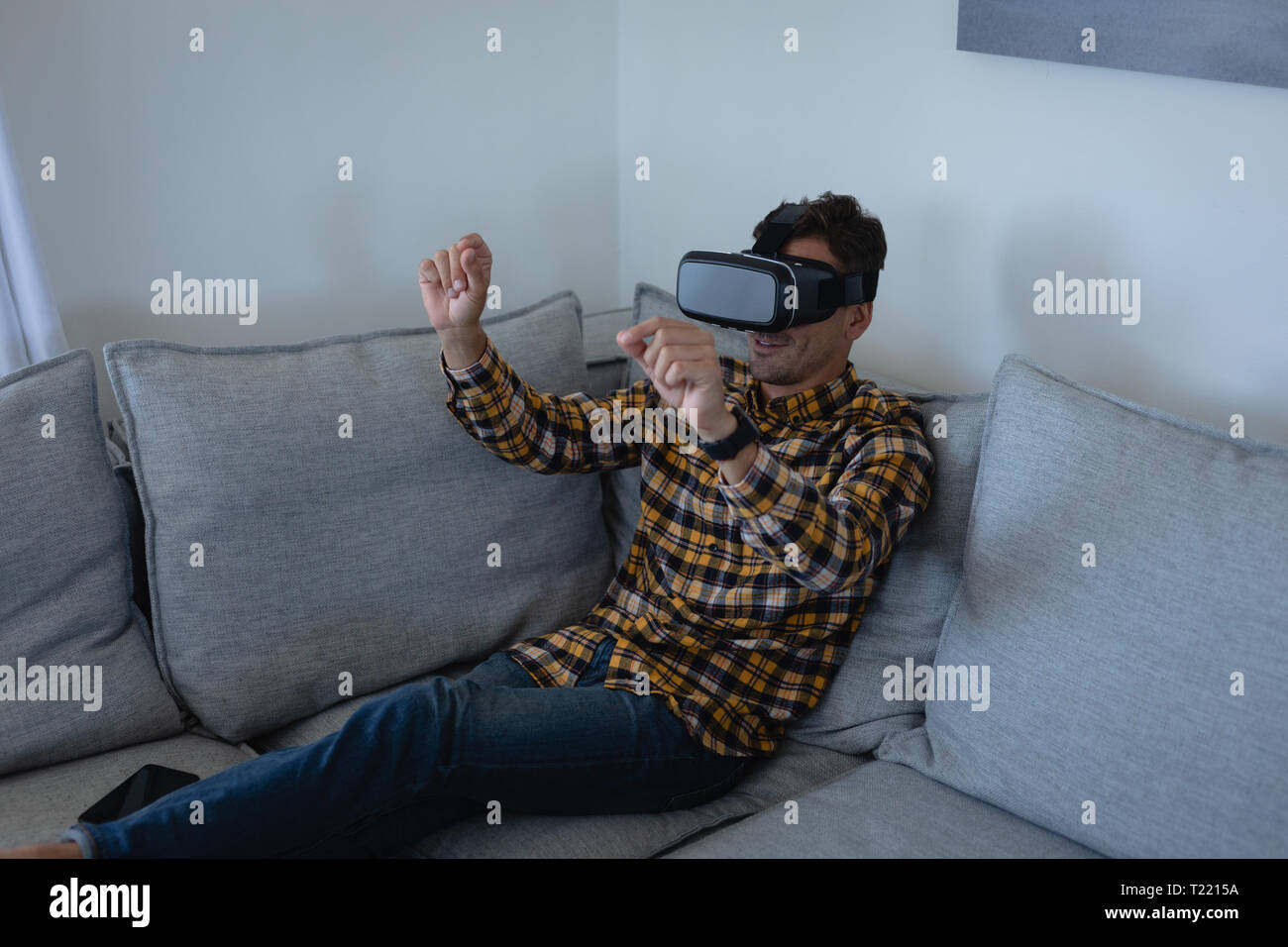 Mann mit virtual-Reality-Kopfhörer zu Hause Stockfoto