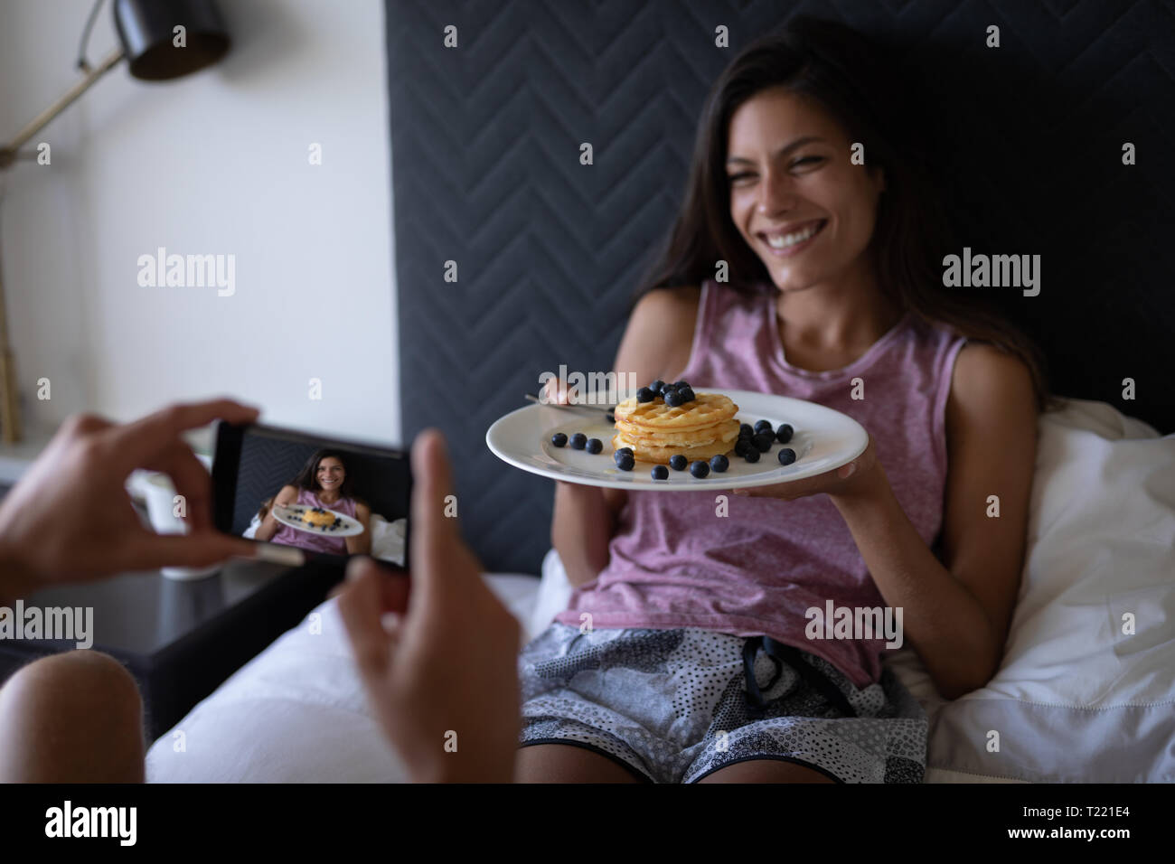 Mann, Foto, während Frau Halteplatte der Frühstück im Bett Stockfoto