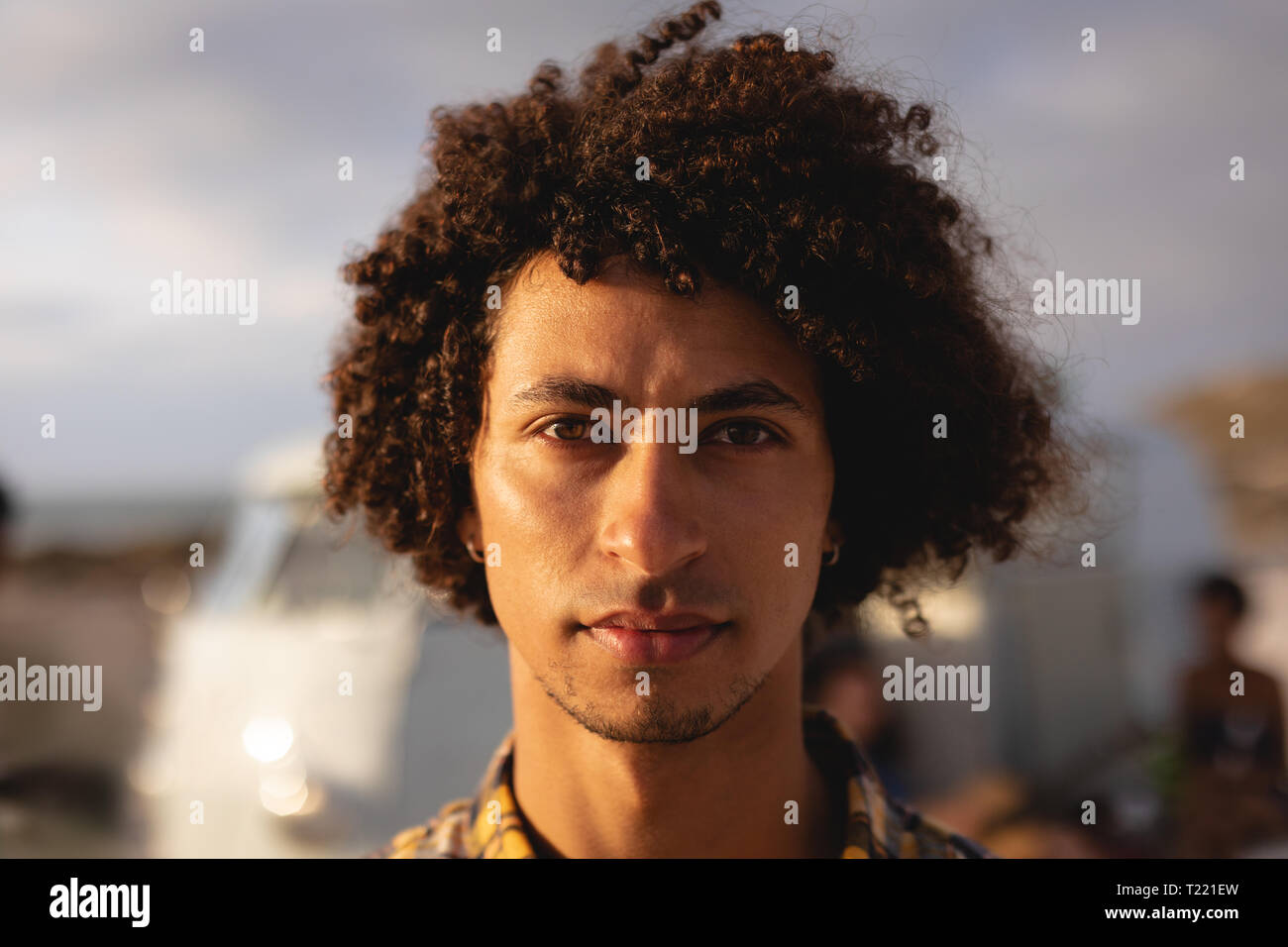 Mixed-race Mann stand, und wenn man die Kamera am Strand an einem sonnigen Tag Stockfoto