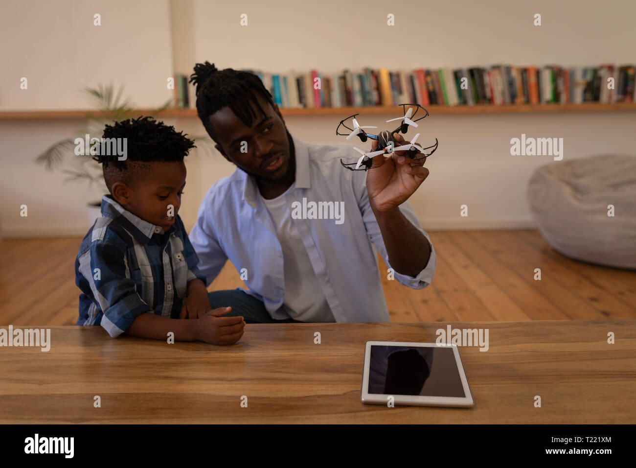 Vater und Sohn spielen mit Drone auf Tisch Stockfoto