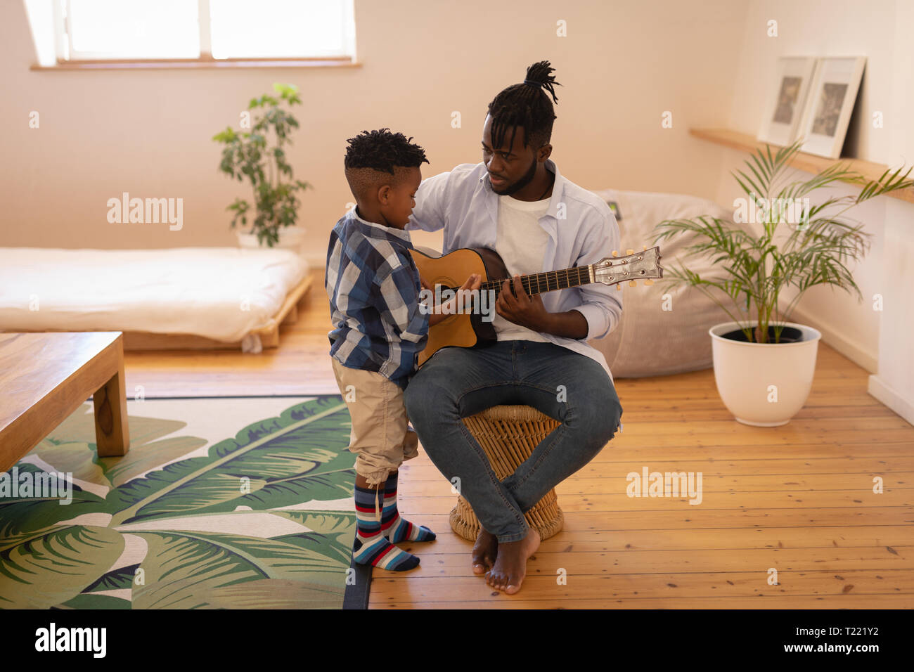 Vater und Sohn spielen mit Gitarre zu Hause Stockfoto