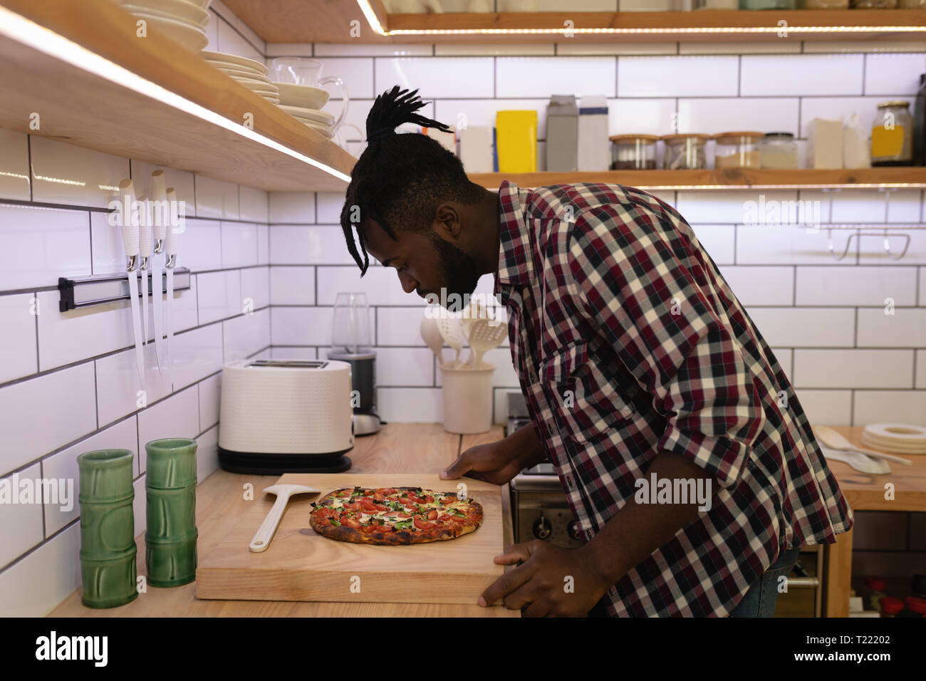 Mann an zubereitet Pizza in der Küche zu Hause suchen Stockfoto