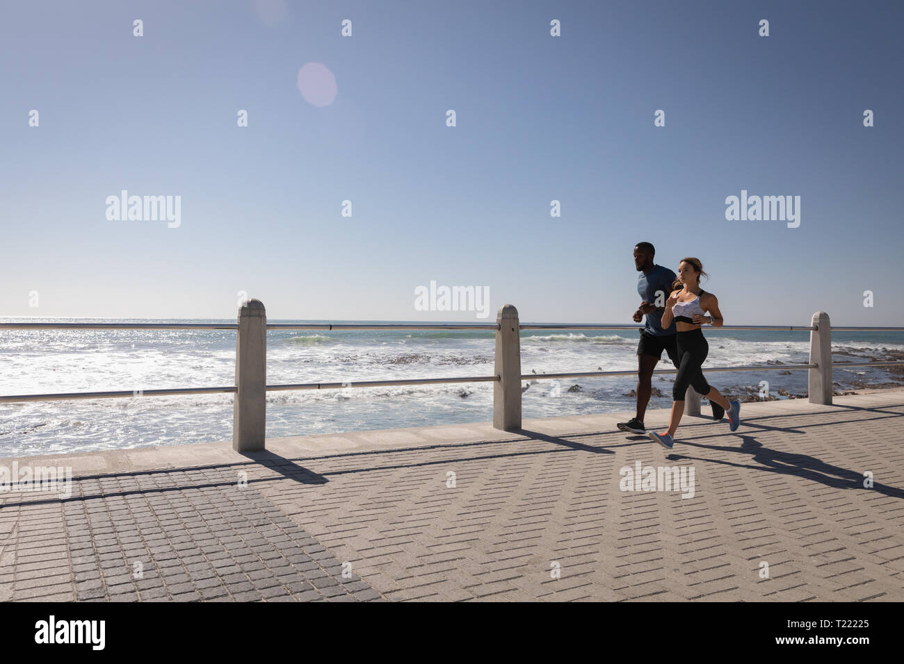 Paar Jogging auf Pflaster an der Strandpromenade Stockfoto