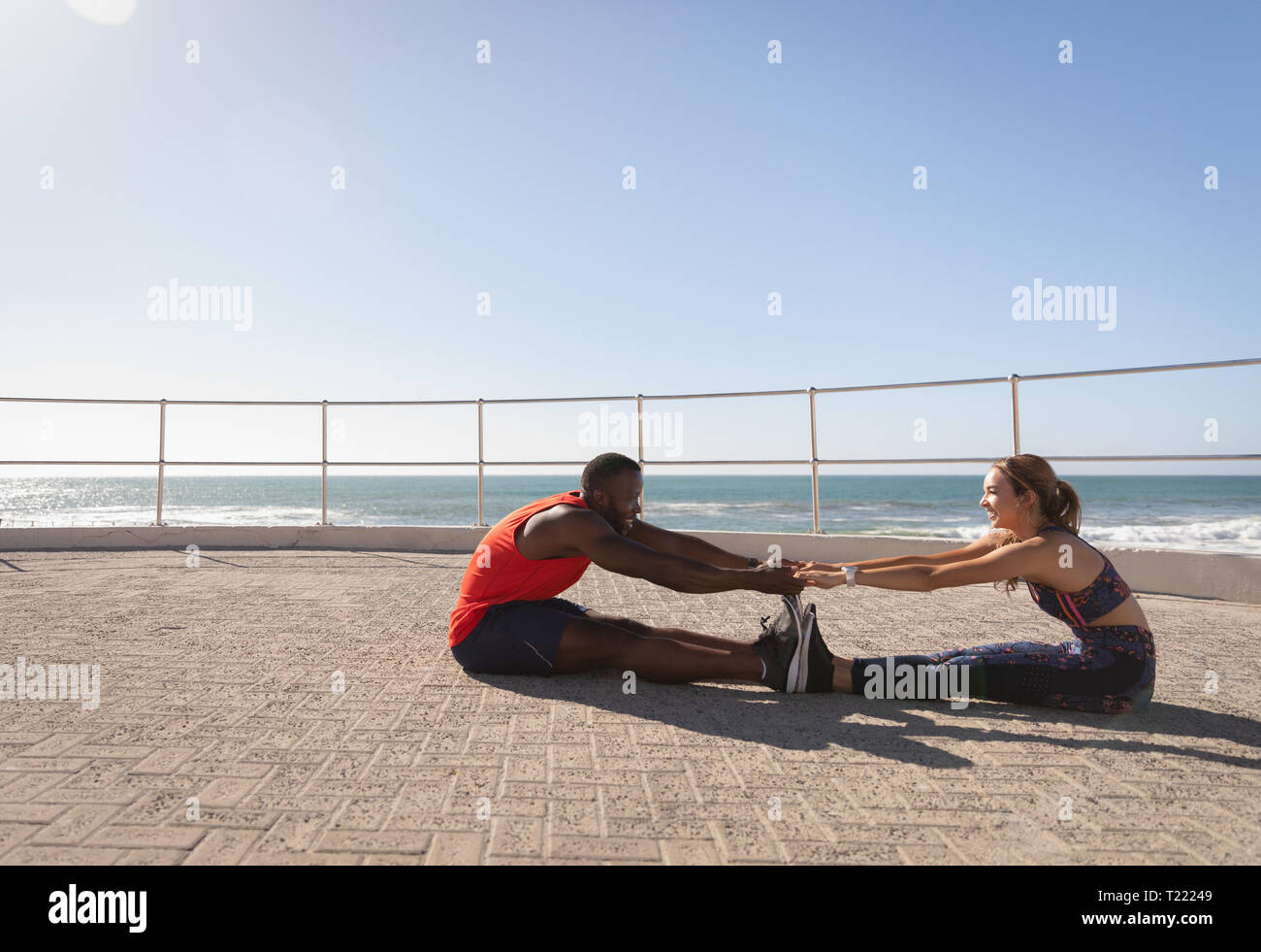 Paar tun stretching Übung auf den Bürgersteig in der Nähe von Promenade, Strand Stockfoto