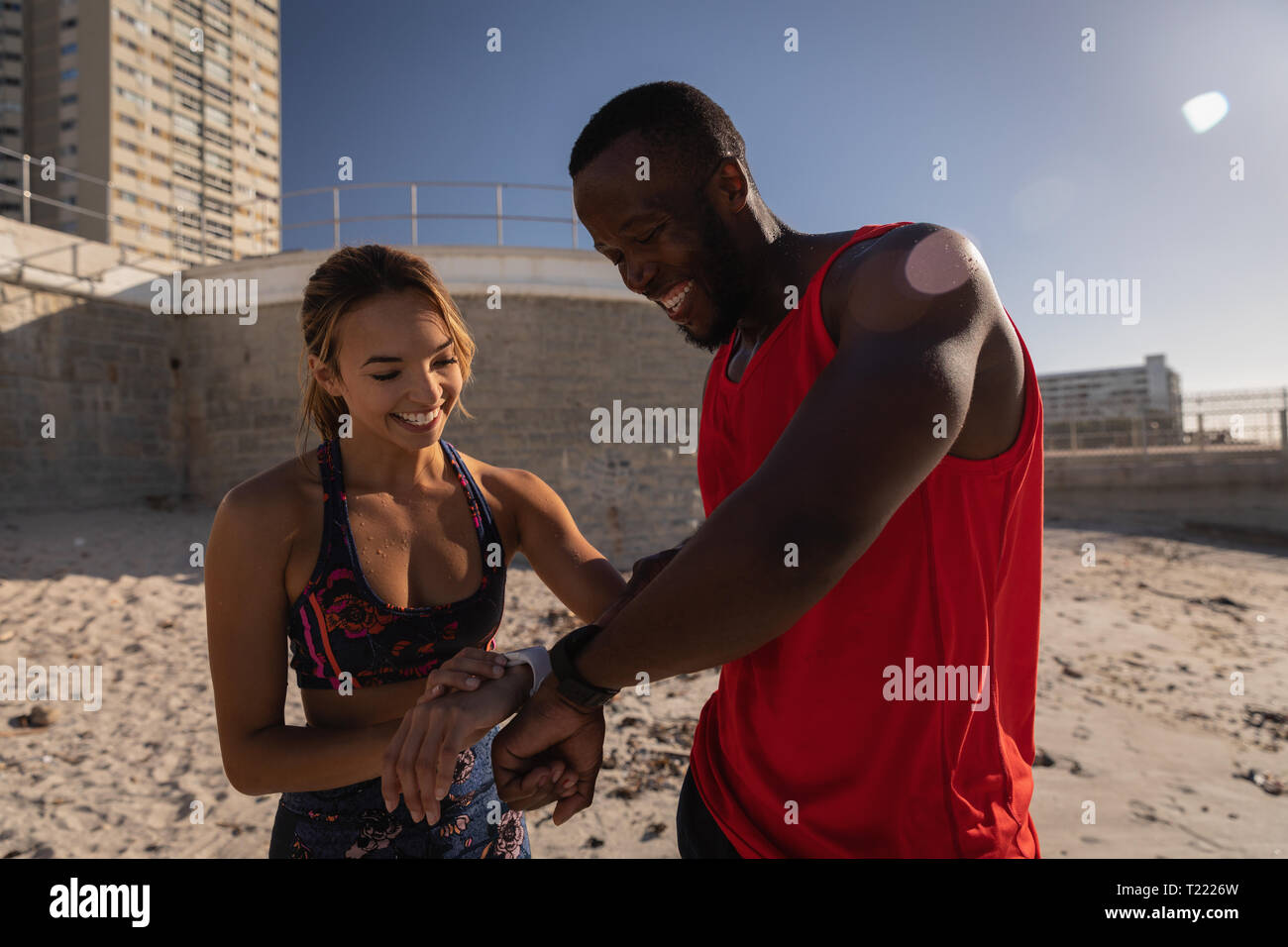 Paar zeigen es smart Watch zu jeden anderen am Strand Stockfoto