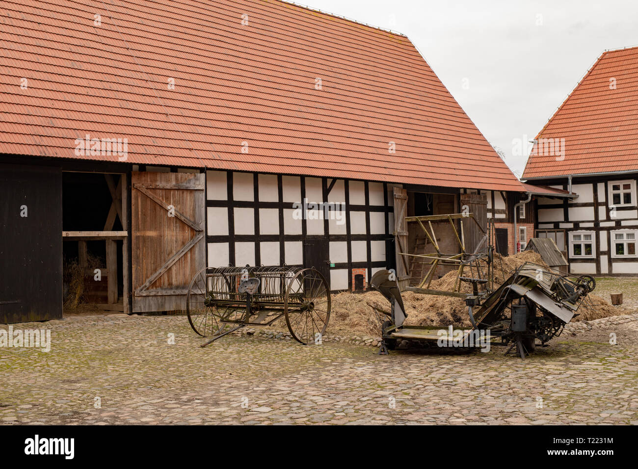 Alter Bauernhof in Mitteleuropa. Maschinen und Geräte im Garten vor dem ...