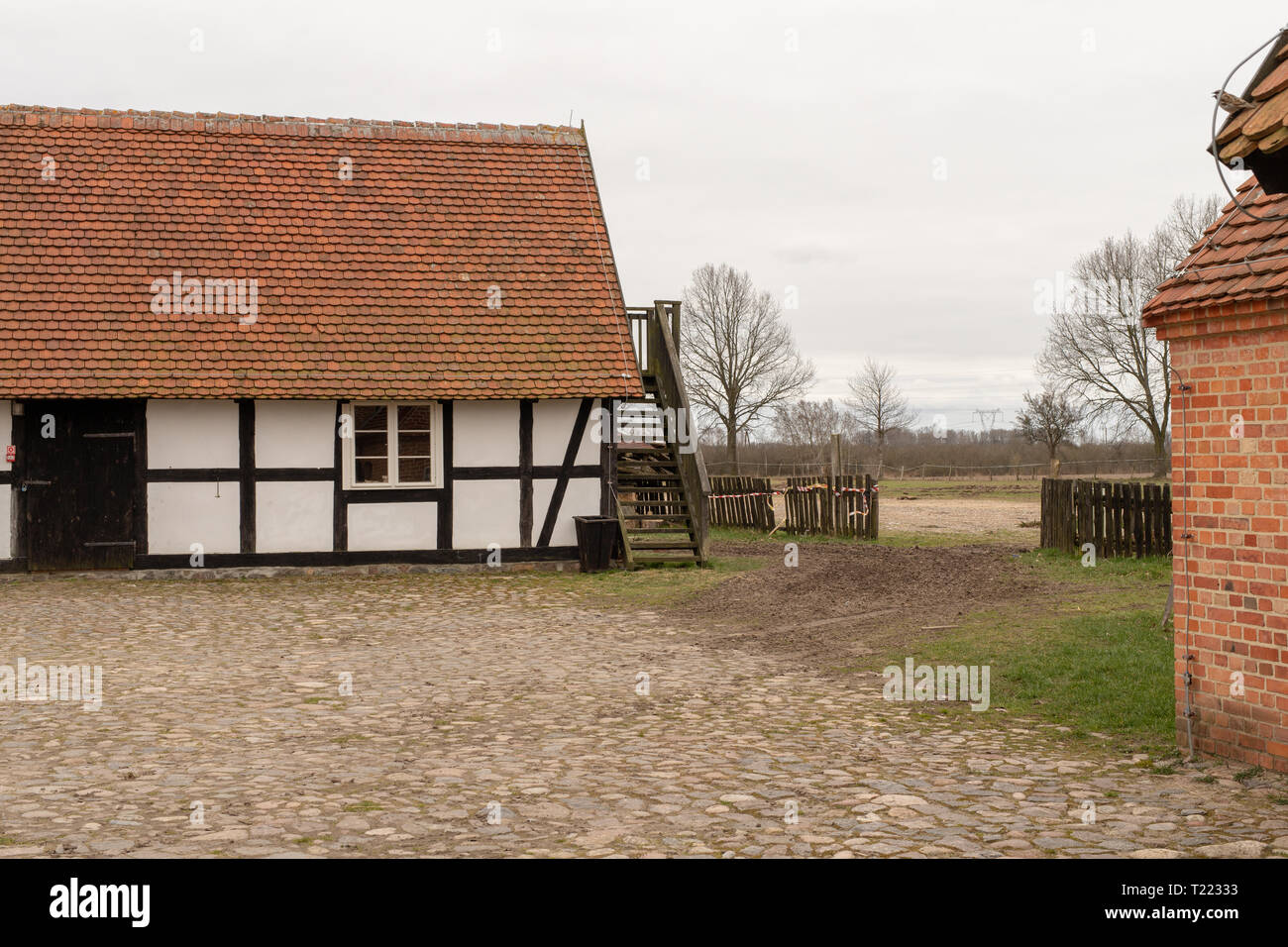 Ein Hinterhof in einem traditionellen Bauernhof. Die alte Methode der Konstruktion in die Landschaft. Saison der Feder. Stockfoto