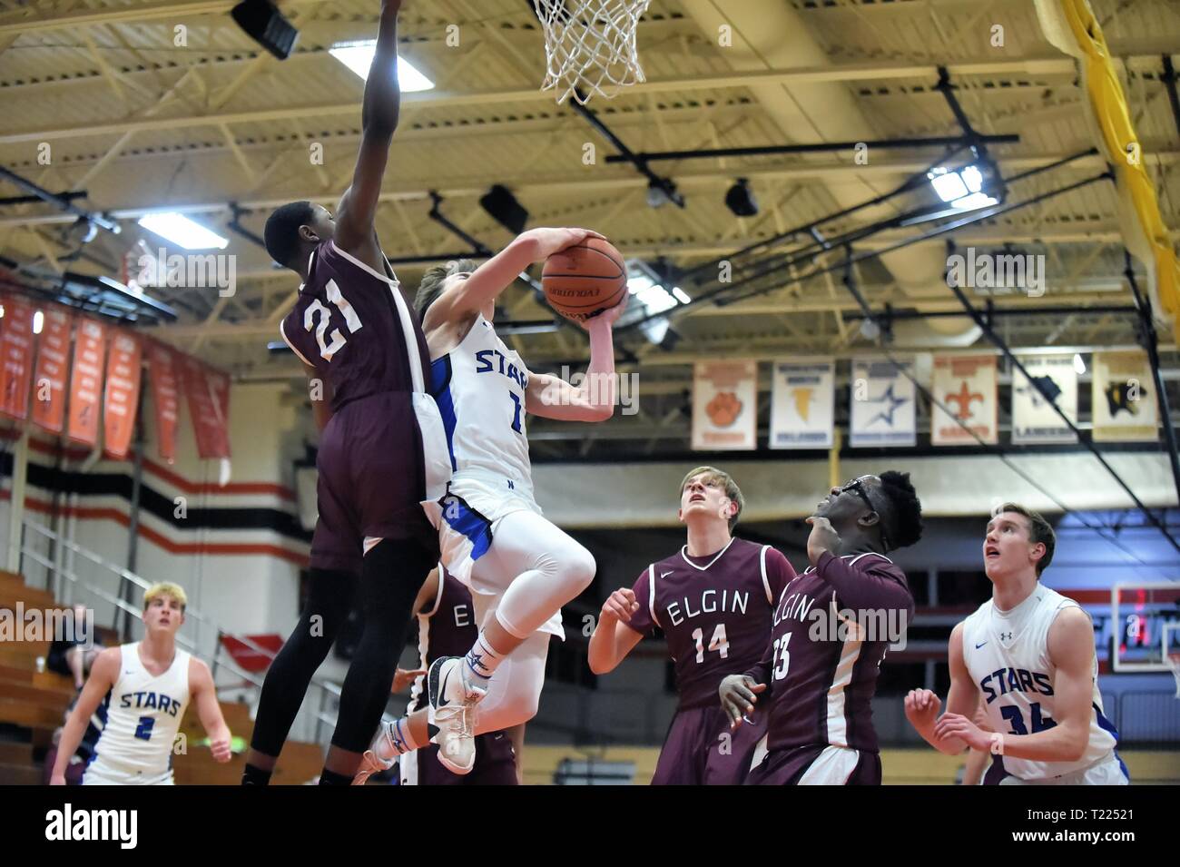 Spieler steigen über den Boden, während Sie die Kugel zum Hoop unter einem Wirt der gegnerischen Verteidiger. USA. Stockfoto