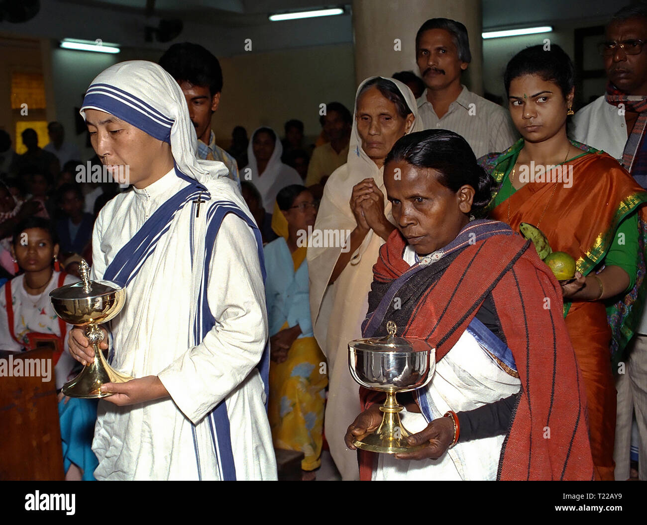 Schwester der Missionarinnen von der Nächstenliebe bringt Geschenke der Altar für die Gemeinschaft Kolkata, Indien 1995 Stockfoto