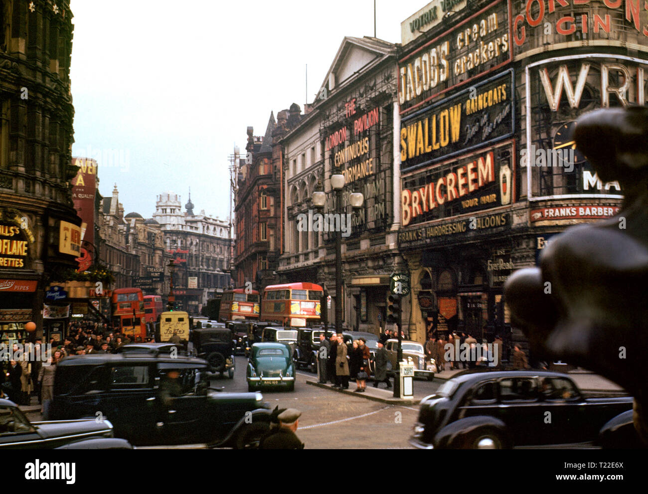 LONDON PICCADILLY 1940er SHAFTESBURY AVENUE ARCHIV 1940er Jahre Vintage-Farbbild der Shaftesbury Avenue voller Verkehr traditionelle schwarze Taxis und rote Londoner Busse, die vom Piccadilly Circus, London um 1940 aus gesehen wurden Stockfoto