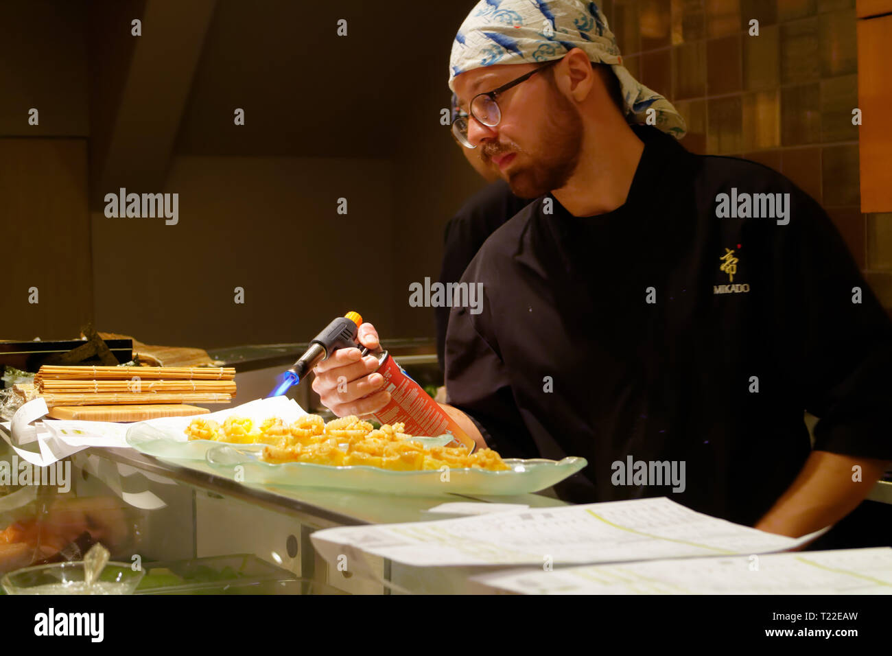 Ein Sushi Chef mit einer Lötlampe squid (IKA) in Mikado Sushi Restaurant in Montreal zu verbrennen - eine Technik, bekannt als Aburi Stockfoto