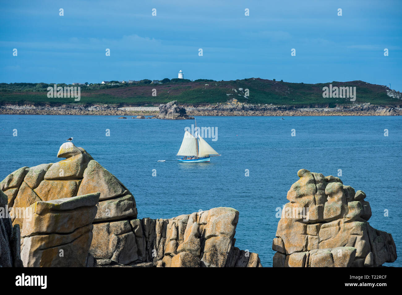 Großbritannien, England, Isles of Scilly, St. Mary's, Segelboot hinter riesigen Granitfelsen Stockfoto