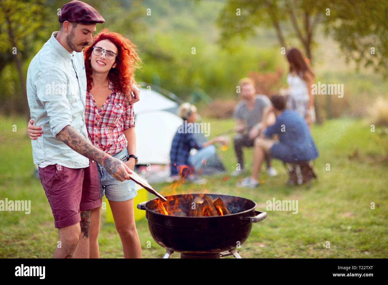 Liebe Paar vorbereiten Grill Feuer am Campingplatz Stockfoto