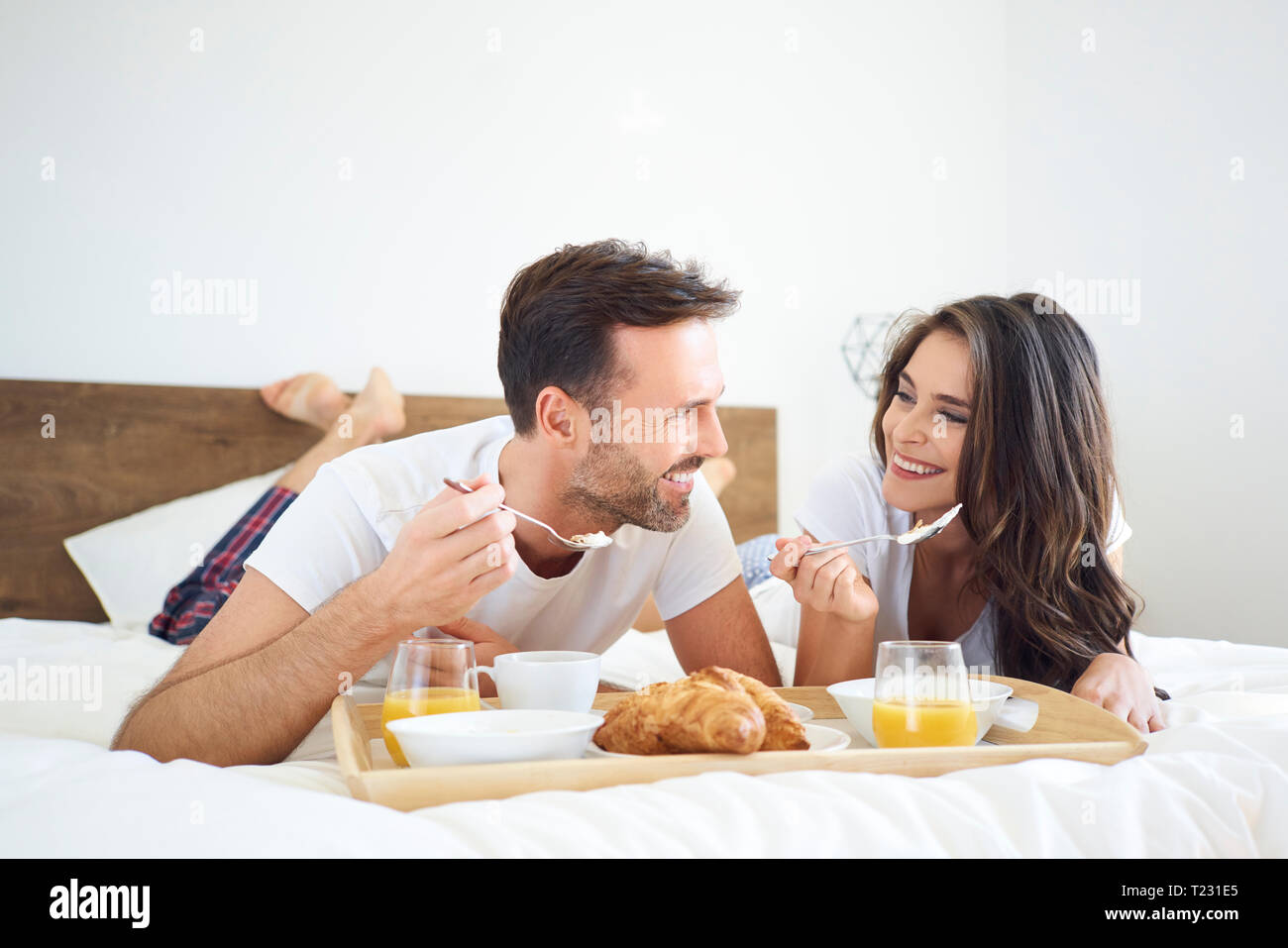 Brautpaar mit Frühstück im Bett Stockfoto