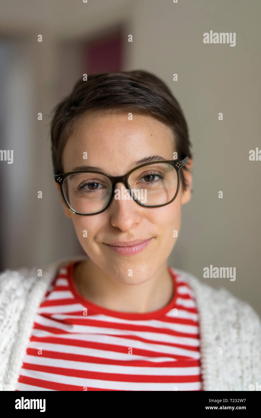 Porträt eines lächelnden jungen Frau mit kurzen Haaren, Brille Stockfoto