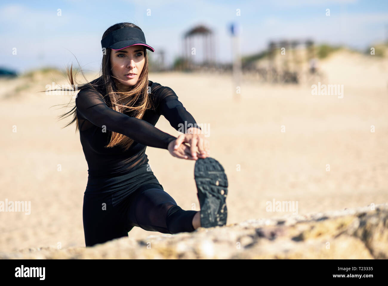 Sportliche Frau ihr Bein stretching auf stein Wand Stockfoto