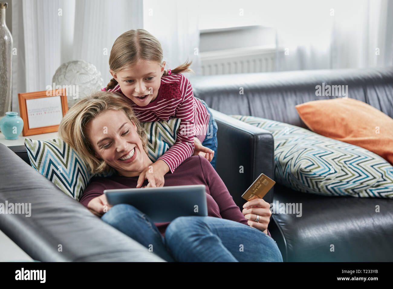 Glückliche Mutter und Tochter Einkaufen online auf der Couch zu Hause Stockfoto