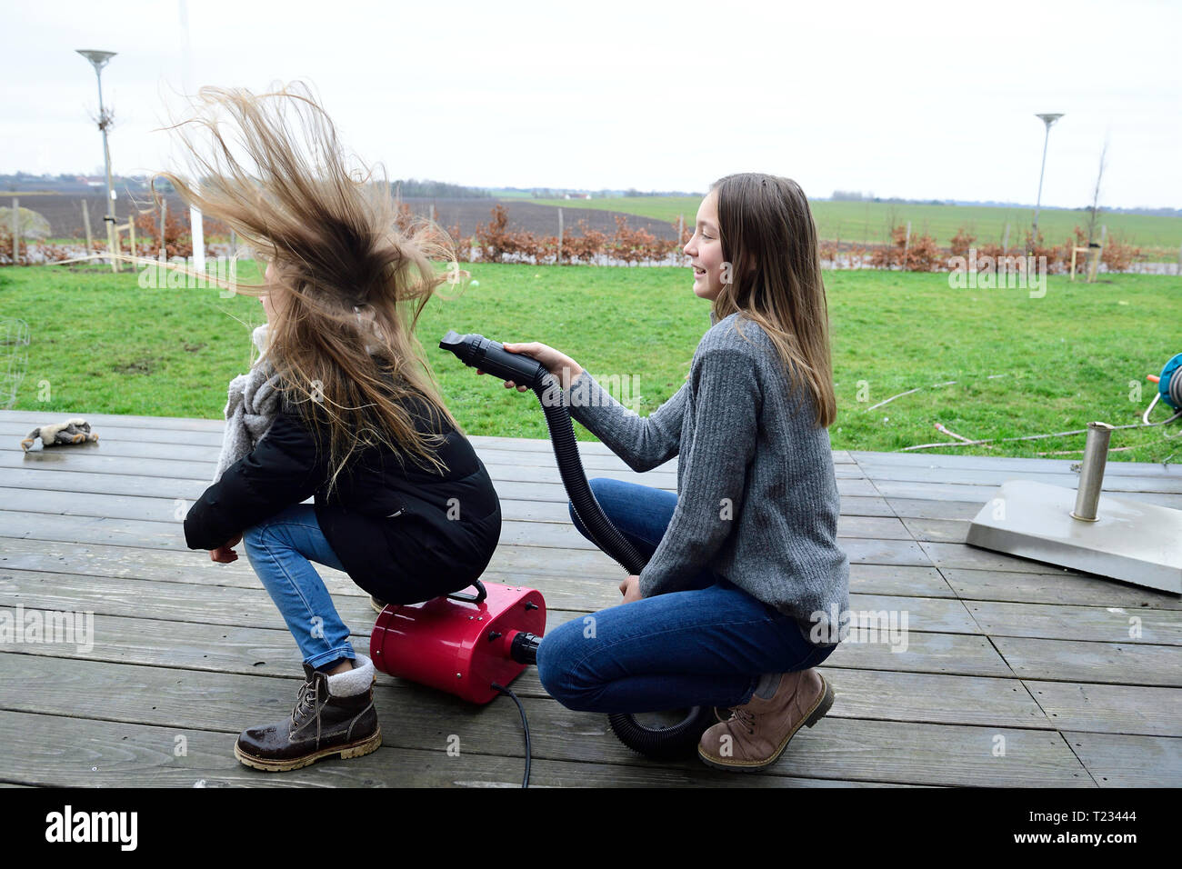 Zwei Freunde spielen mit Gebläse auf der Terrasse Stockfoto