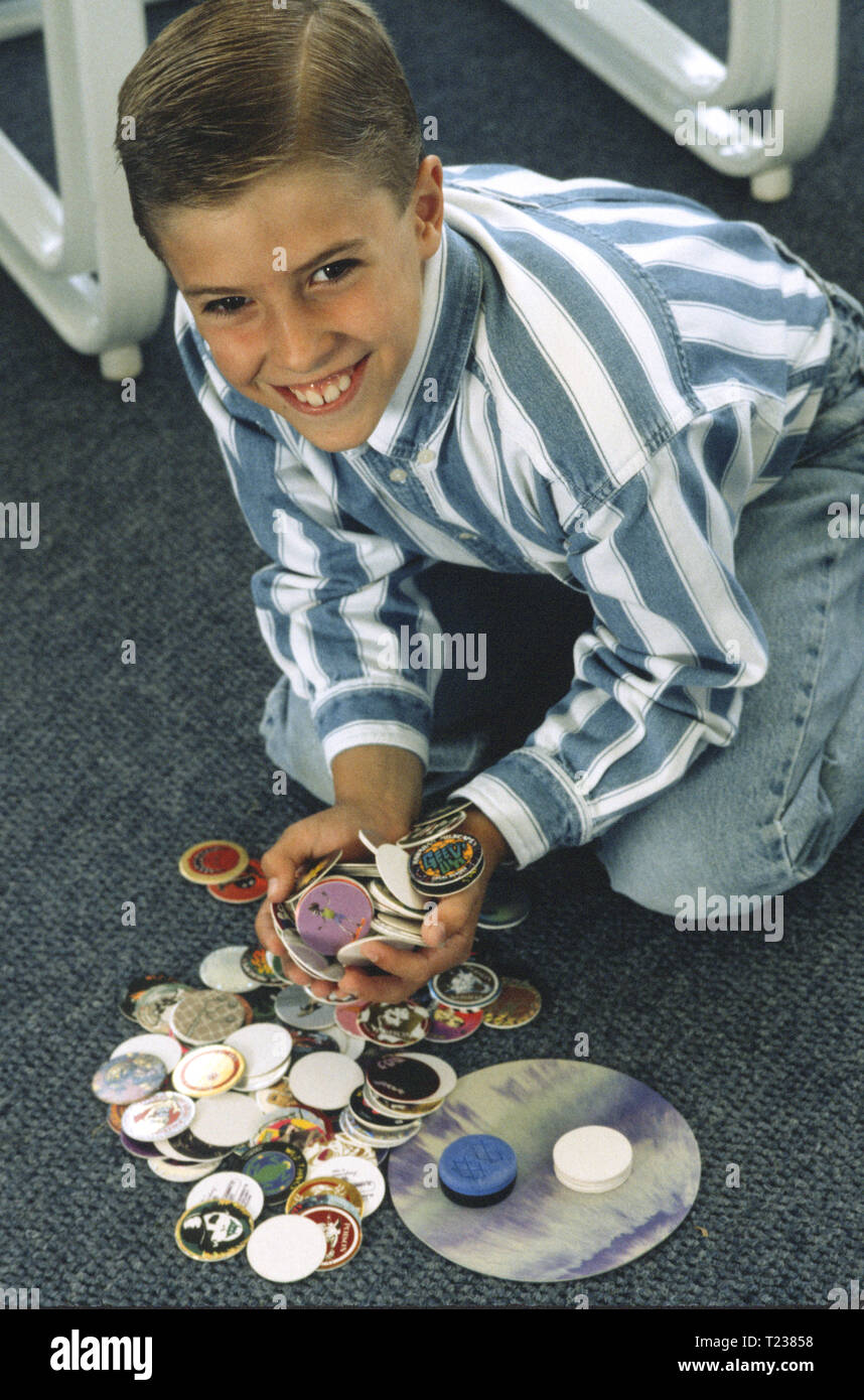 7 Jahre alten Jungen sammeln Milch Pogs, USA Stockfoto