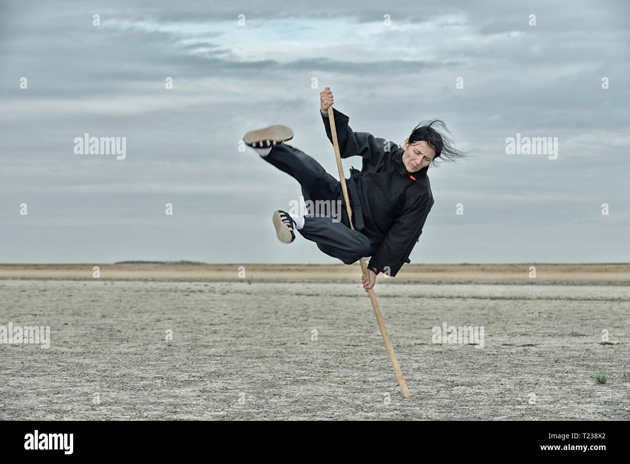 Frau tun Qigong mit Stick. Stockfoto