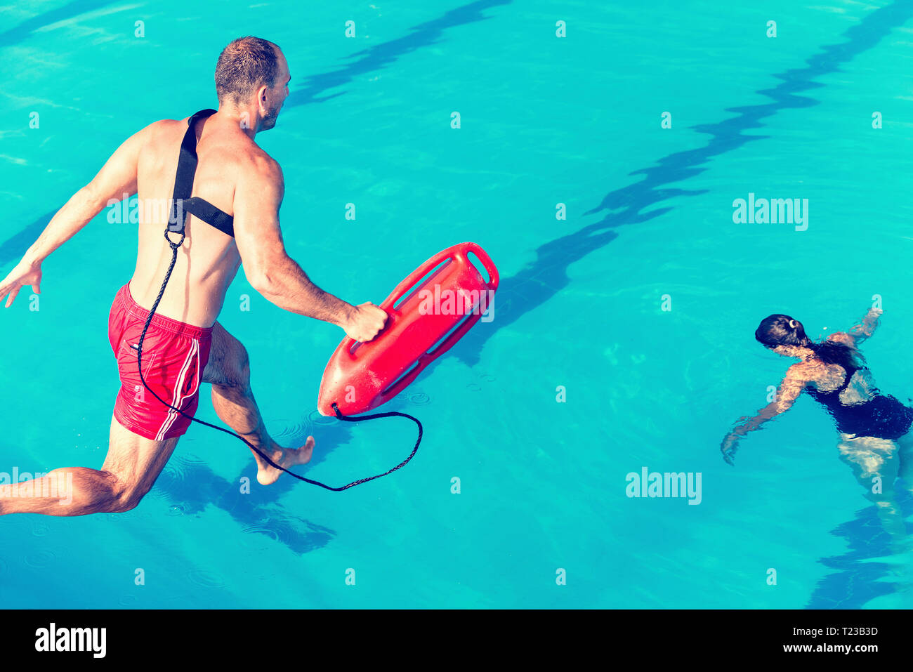 Rettungsschwimmer Rescue Kurs - Rettungsschwimmer in Richtung Frau springen. Getönten Bild. Stockfoto