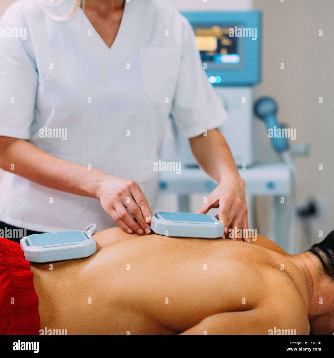 Magnettherapie. Physiotherapeuten Platzierung von Magneten auf Patienten zurück. Stockfoto