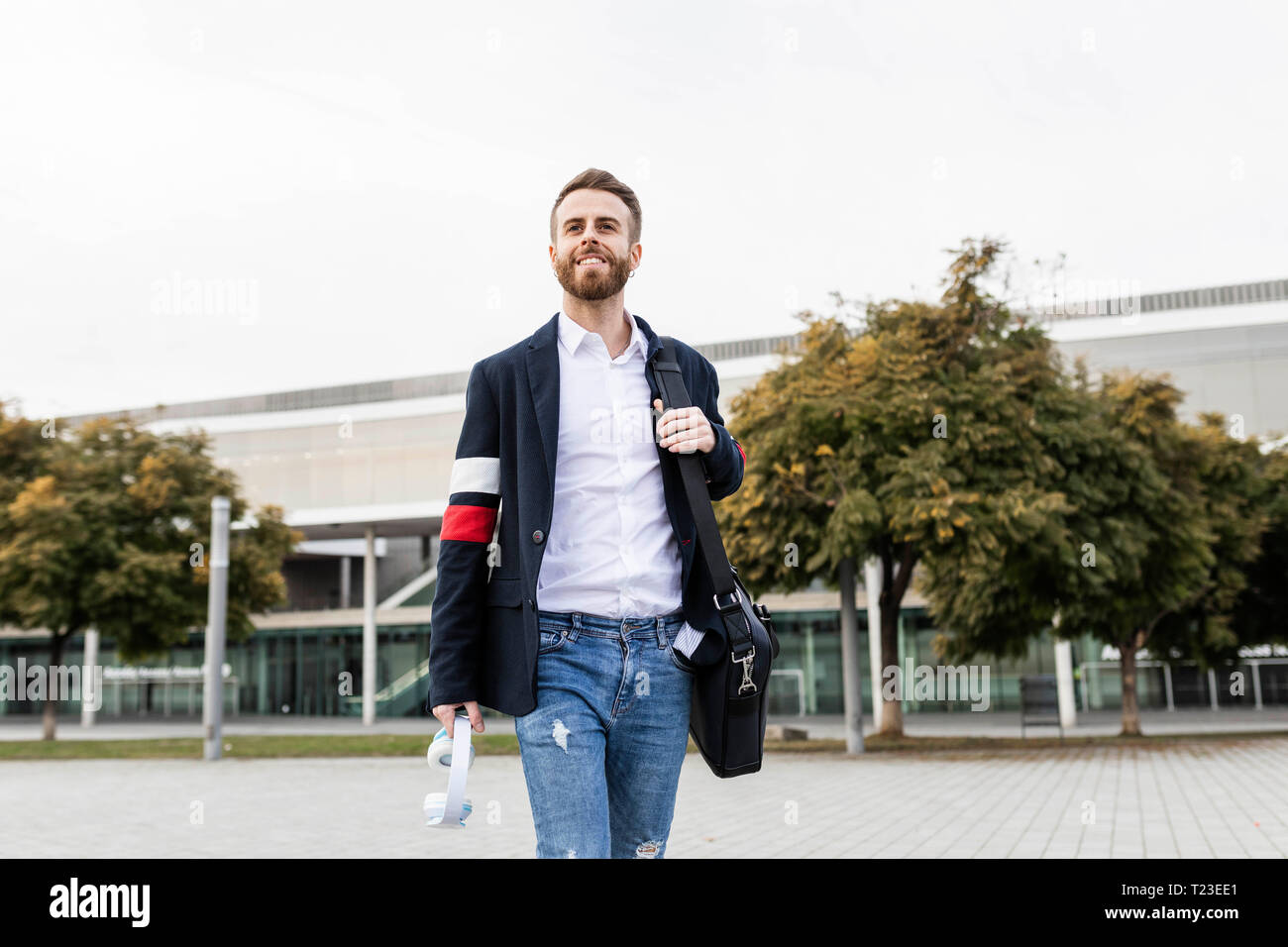 Stilvolle Geschäftsmann zu Fuß in der Stadt Stockfoto