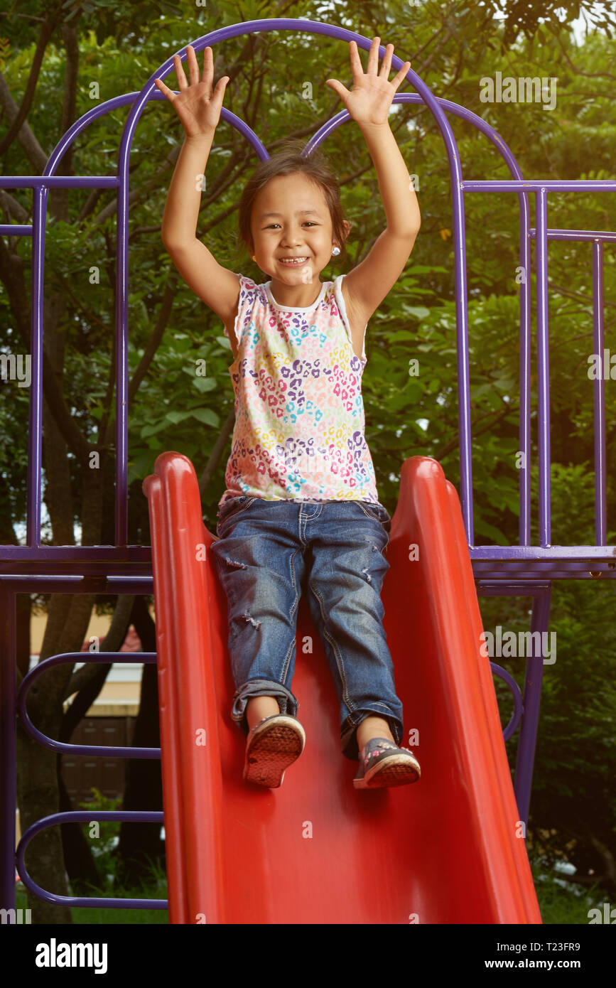 Asiatische Mädchen auf einer Folie an einem Park. Filipina Kid. Stockfoto