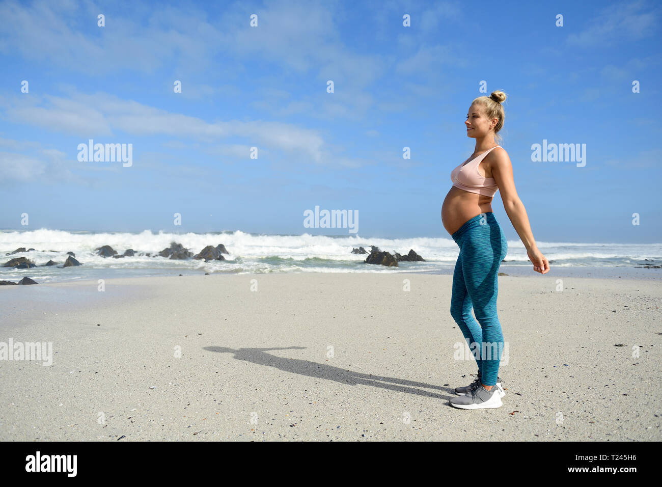 Aktive schwangere Frau am Strand Stockfoto