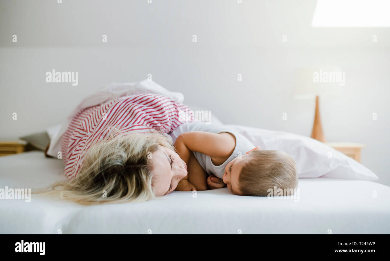 Mutter und Kleinkind Sohn im Bett zu Hause liegen Stockfoto