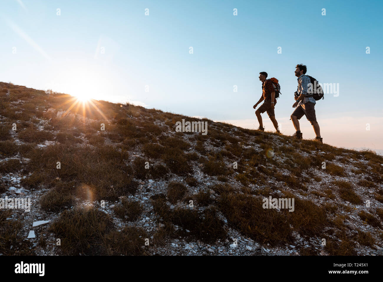 Italien, Monte Nerone, zwei Männer wandern in die Berge bei Sonnenuntergang Stockfoto