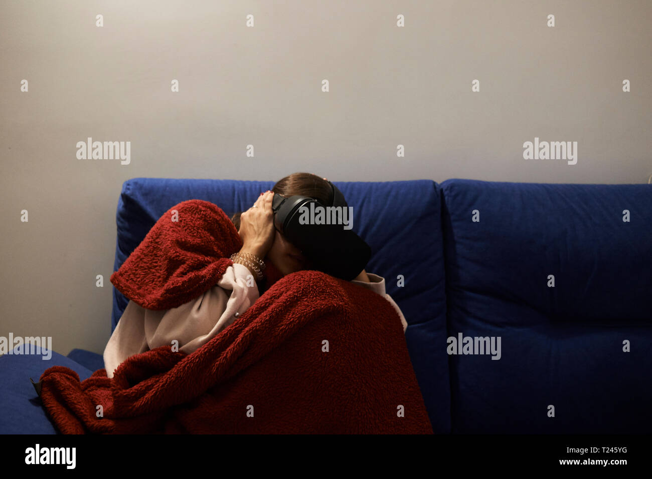 Erschrocken Weibchen allein zu Hause in der Nacht mit Virtual reality Headset aufzupassen Film. Stockfoto