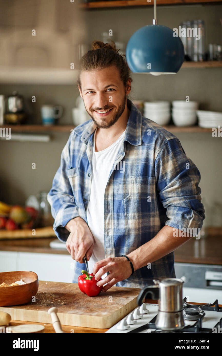 Junger Mann essen zu Hause vorbereiten, schneiden Gemüse Stockfoto