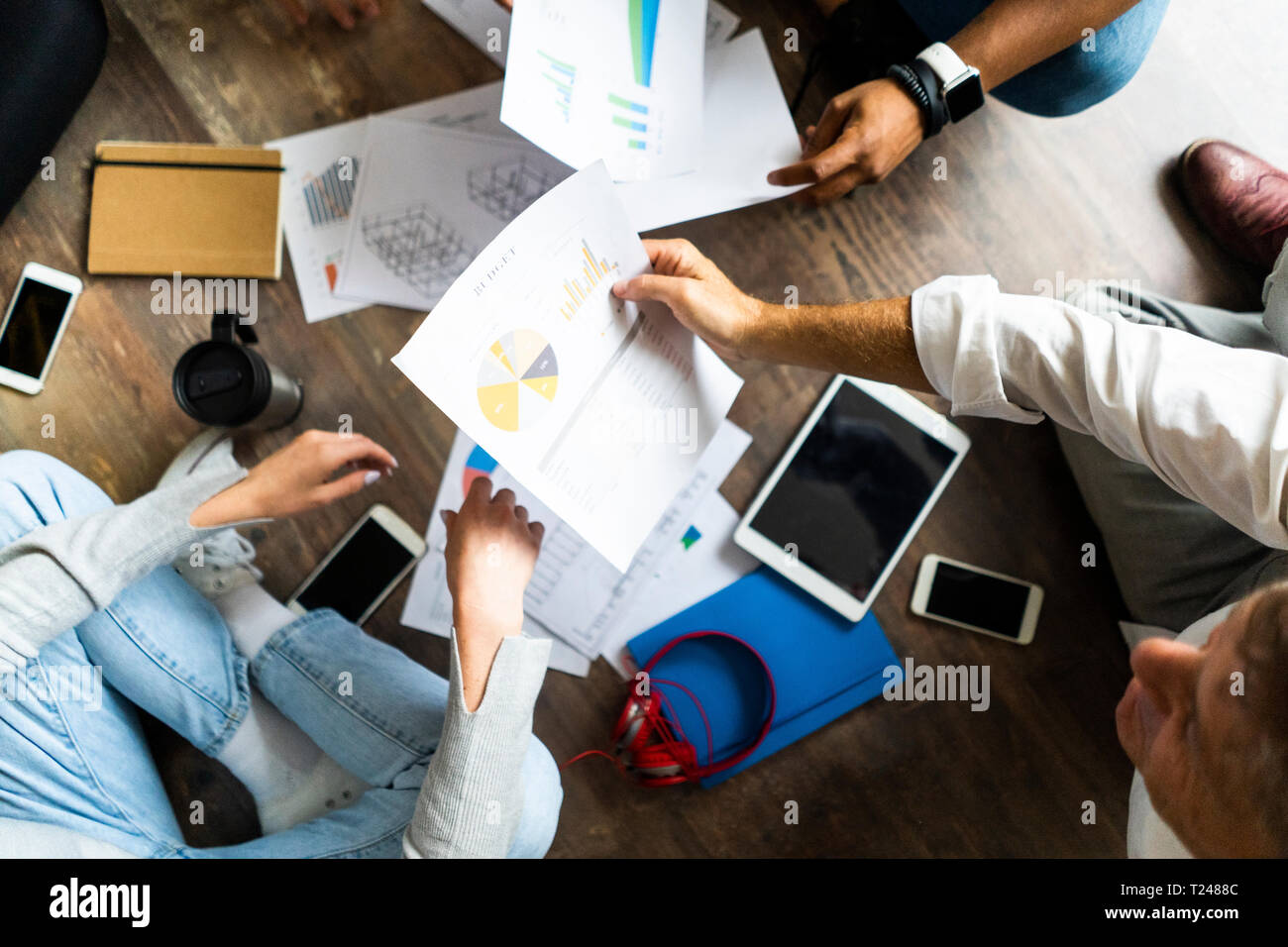 Blick von oben auf die Business Team sitzen auf dem Boden diskutieren Dokumente Stockfoto