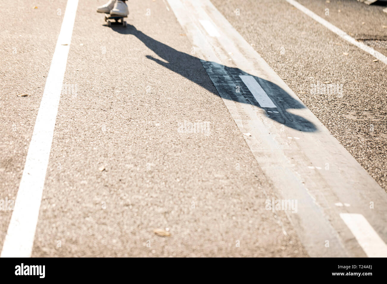 Schatten der Mann skateboarding auf Radweg Stockfoto