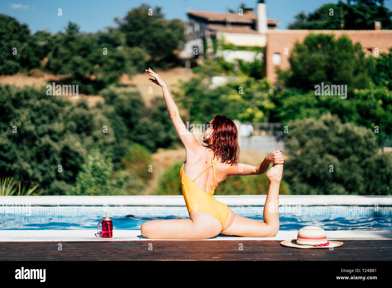 Hübsche Frau in einem Badeanzug Yoga am Pool Stockfoto