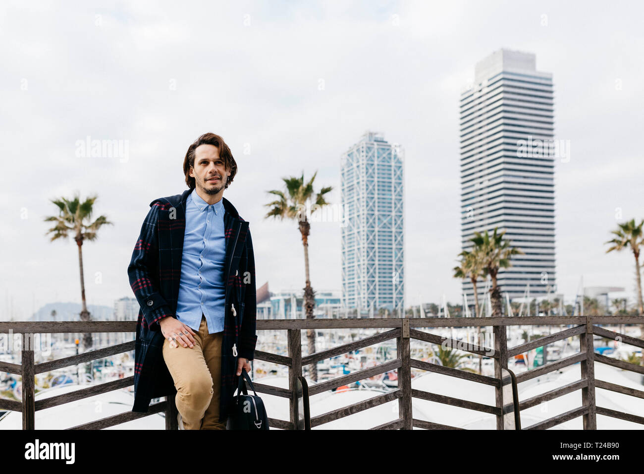 Spanien, Barcelona, entspannt man nach der Arbeit mit Hafen und Stadt Hintergrund Stockfoto