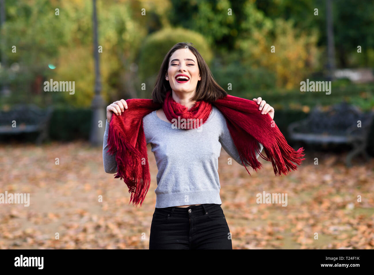Portrait von Lachende junge Frau das Tragen der roten Schal im Herbst Stockfoto