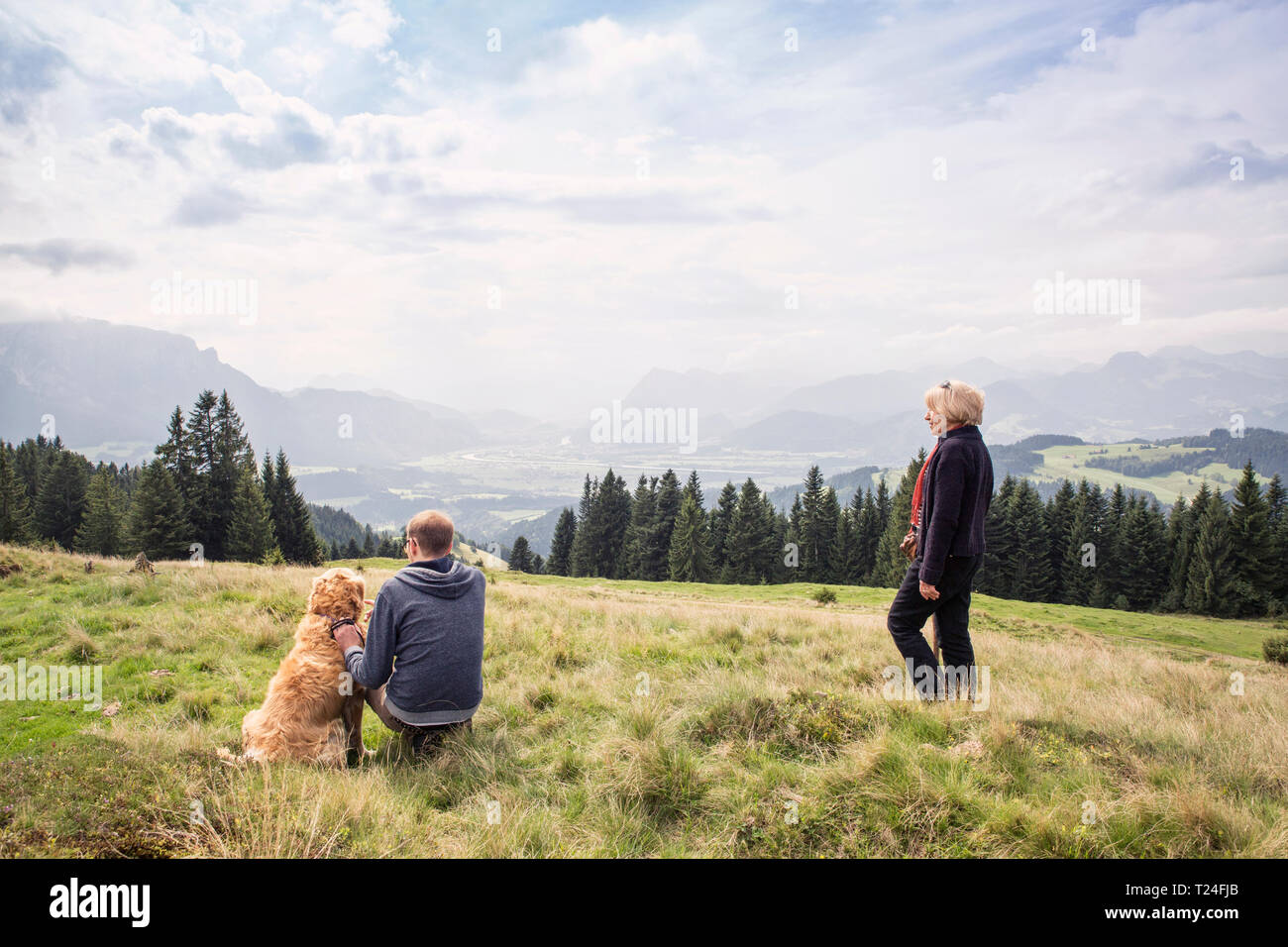 Österreich, Tirol, Kaisergebirge, Mutter und erwachsener Sohn mit Hund auf eine Wanderung in den Bergen Stockfoto