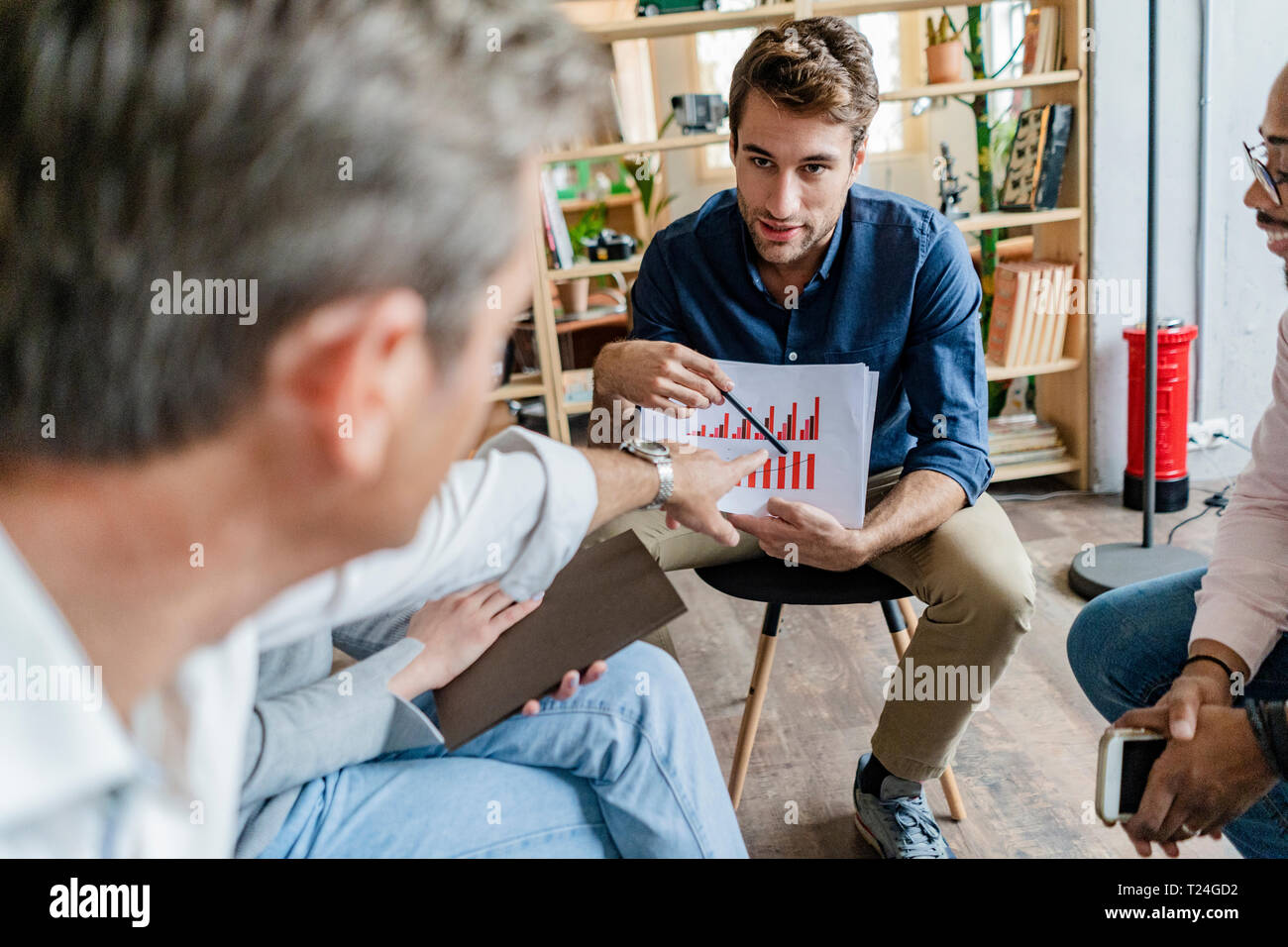 Business Team diskutieren Balkendiagramm im Loft Büro Stockfoto