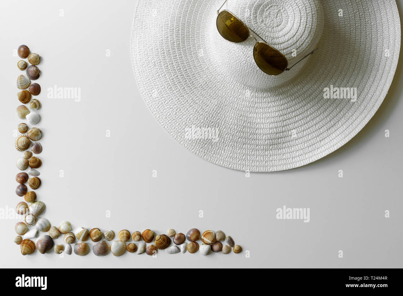 Seashells Rahmen und Sommermode Objekte - aviator Sonnenbrille und Stroh Hut als Ferienhäuser Arrangement mit kopieren. Stockfoto