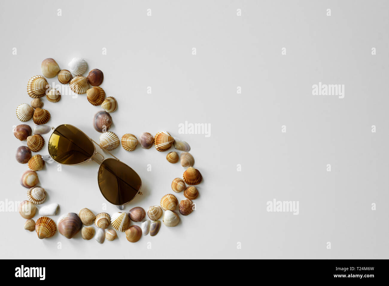 Minimalistischer Sommer Idee für Set-up von aviator Sonnenbrille und herzförmige Muscheln mit Kopie Raum auf weißem Hintergrund erstellt. Stockfoto