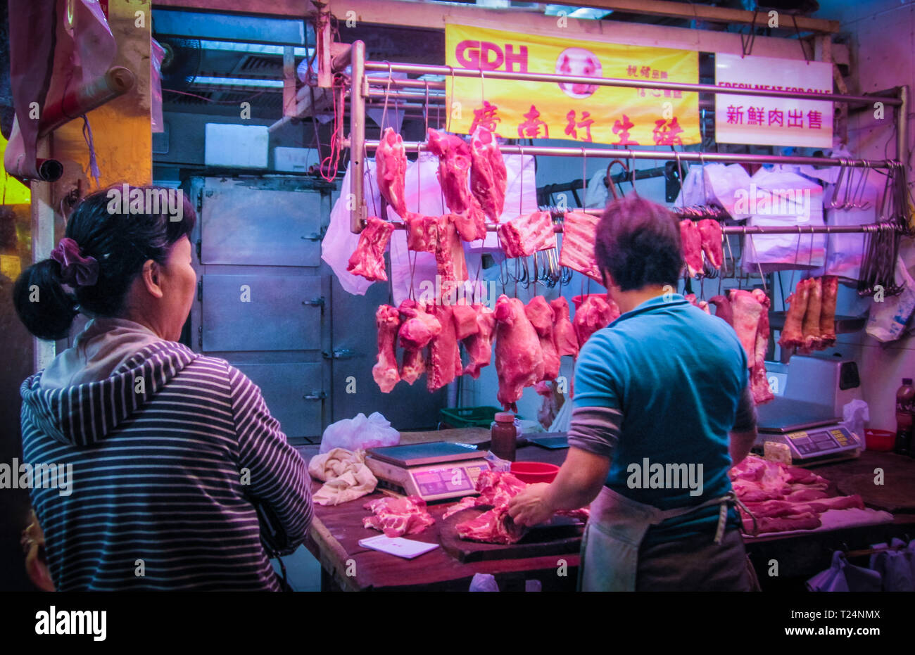 Hongkong, 31.12.2013: Straße: Schlachter zerschneiden Schweinefleisch für Verkauf an Fa Yuen Street Market in Mong Kok, Hong Kong. Stockfoto